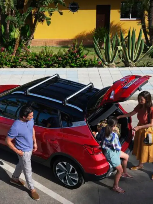 Vrouw en kind in een kofferbak van een SEAT Arona, man die ernaast loopt