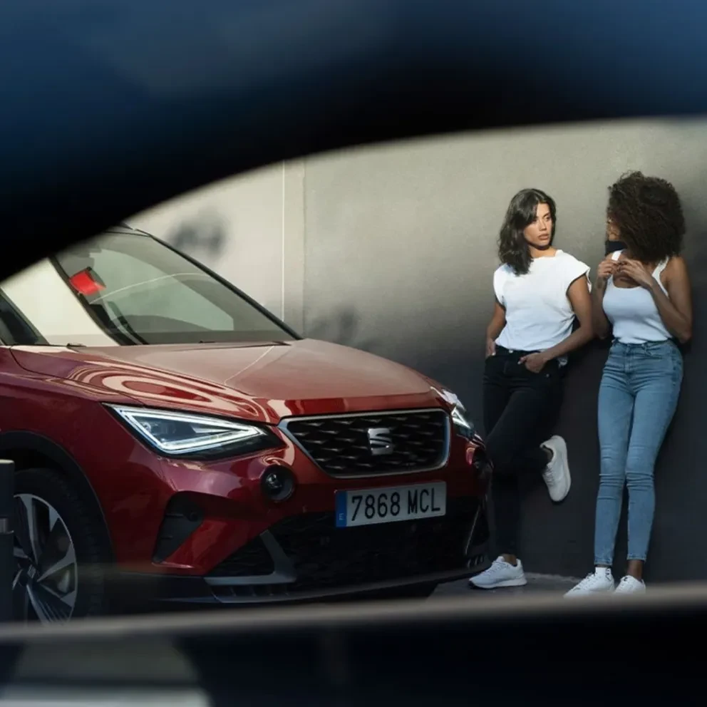 Twee vrouwen leunend tegen een muur naar een SEAT Arona