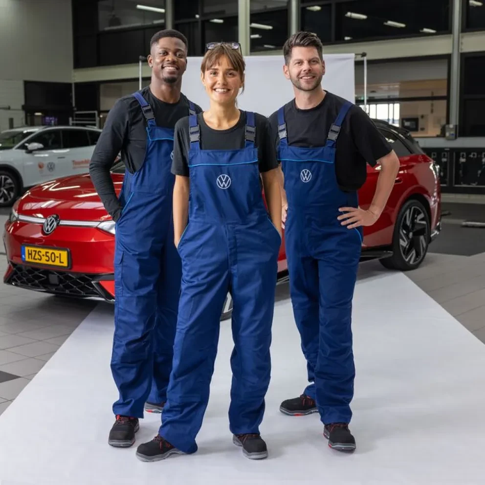 3 monteurs in een Volkswagen werkplaats voor een rode ID.7