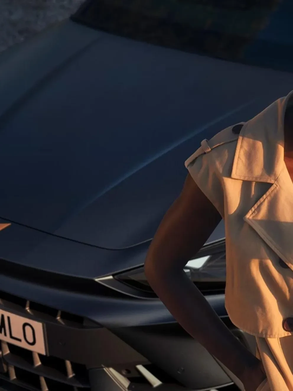 Vrouw die leunend tegen een CUPRA Born op haar mobiel kijkt