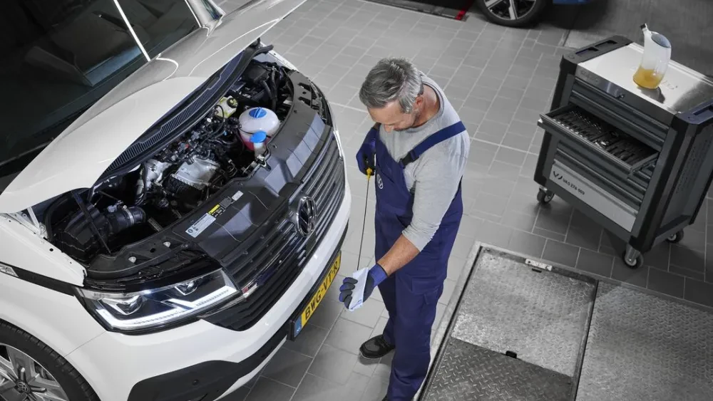 Monteur die olie peilt bij Volkswagen Transporter