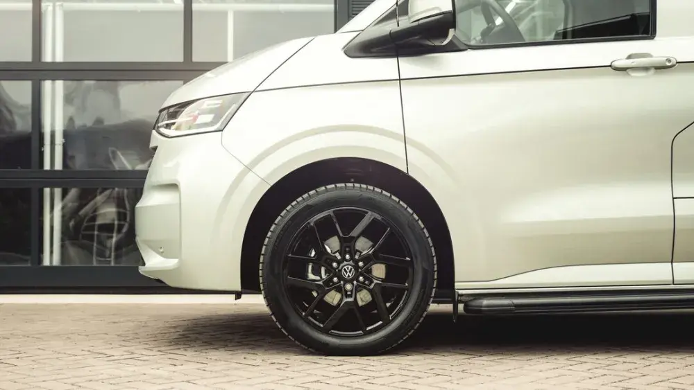 Detailfoto van een witte Volkswagen Transporter met zwarte lichtmetalen velgen