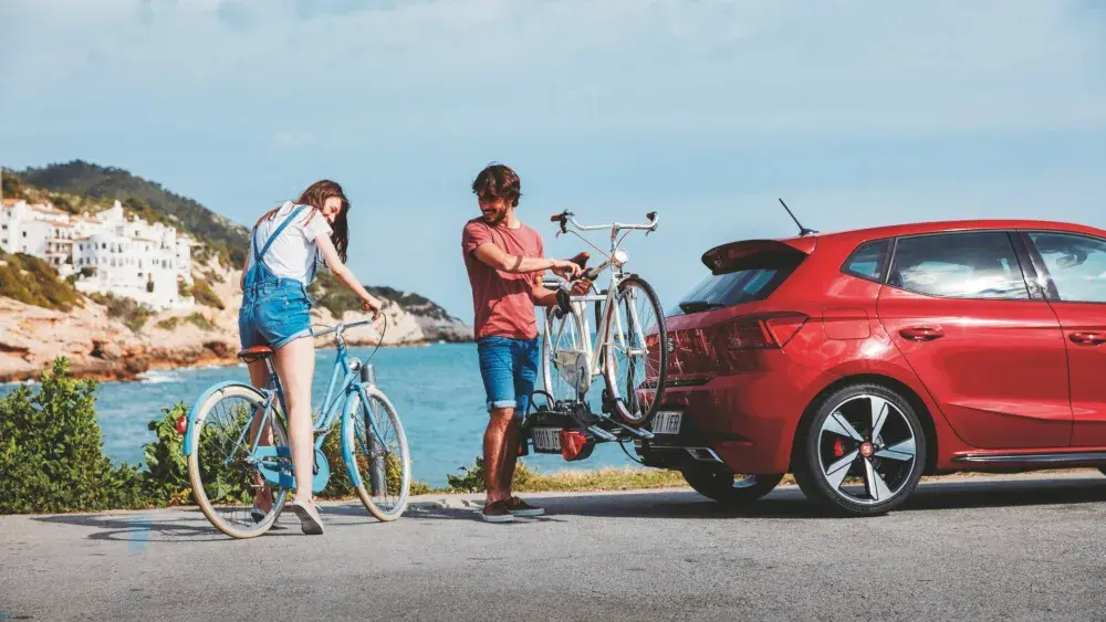 Man en vrouw die fietsen op een fietsendrager zetten op een SEAT Ibiza