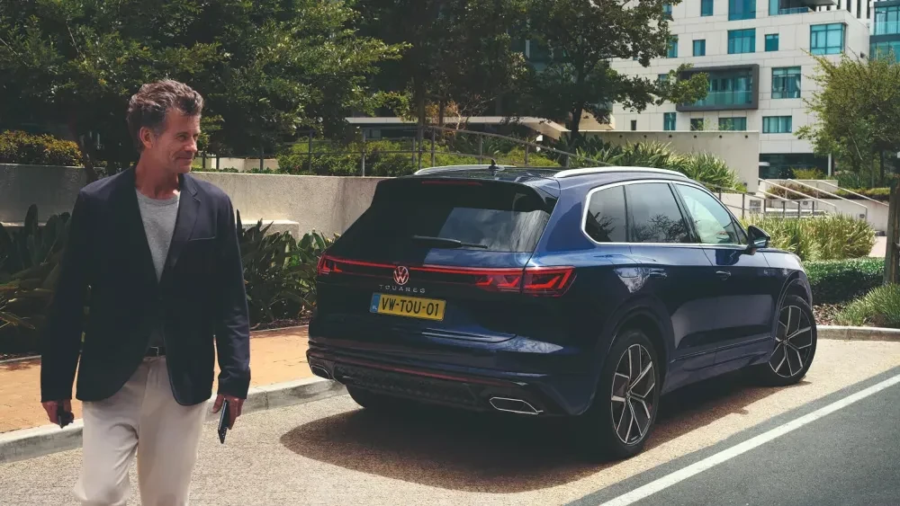 Man die wegloopt bij een Volkswagen Touareg