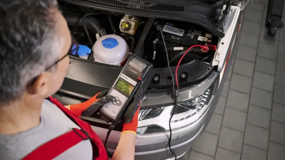 Monteur met een startaccu bij een Volkswagen Transporter
