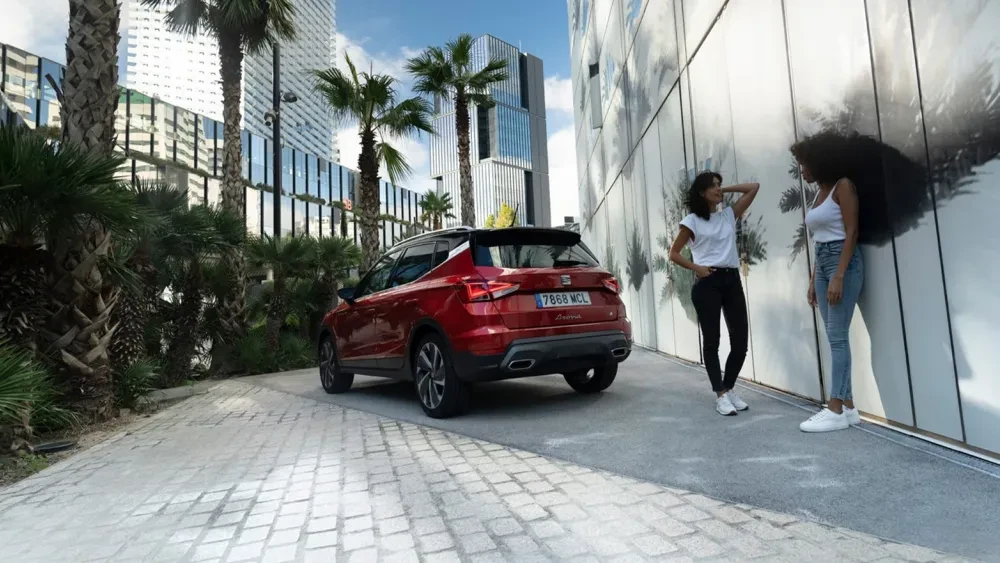 Man en vrouw naast een SEAT Ateca in een straat met palmbomen
