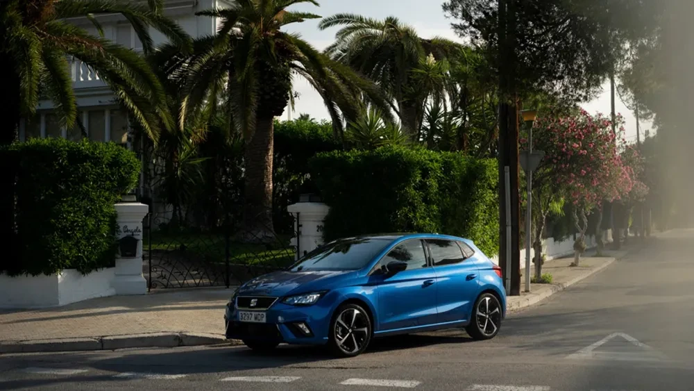Blauwe SEAT Ibiza in een straat met palmbomen