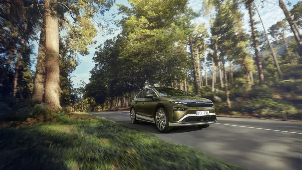 Mosgroene Škoda Enyaq rijdend op een weg