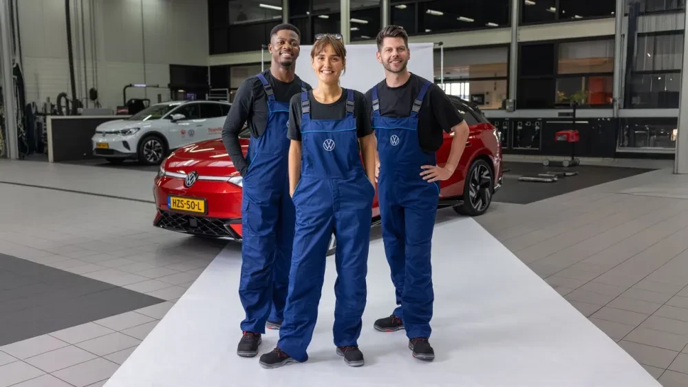 3 monteurs in een Volkswagen werkplaats voor een rode ID.7