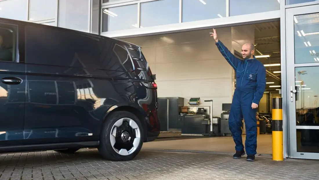 Monteur die een Volkswagen ID. Buzz uitzwaait