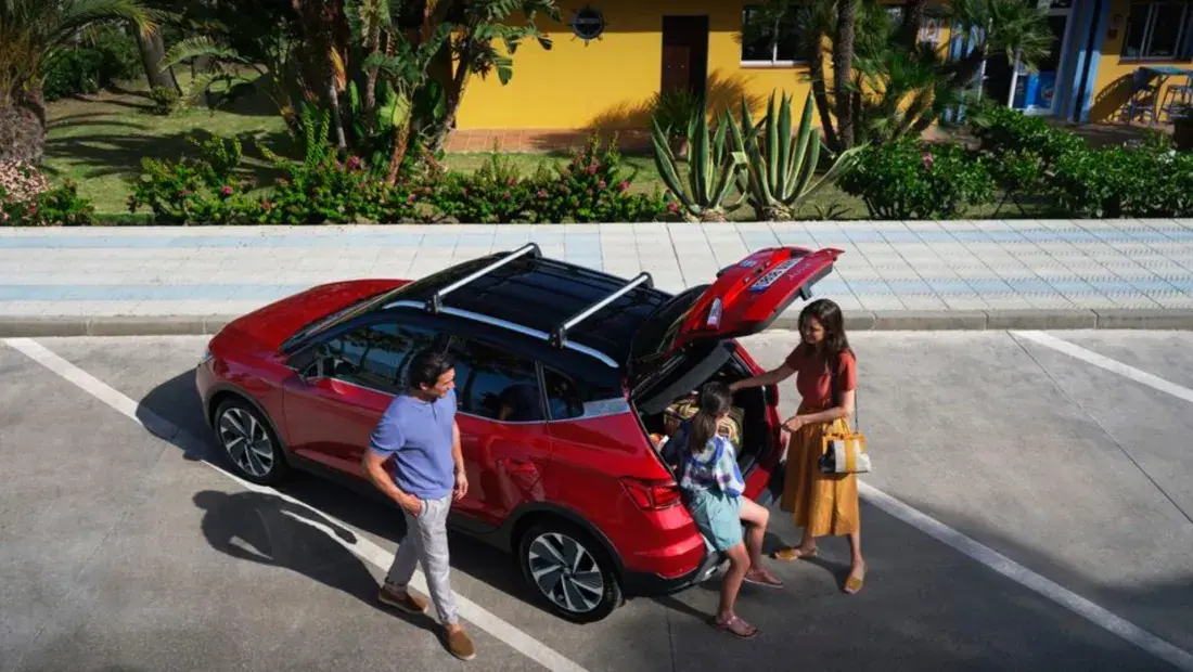 Vrouw en kind in een kofferbak van een SEAT Arona, man die ernaast loopt
