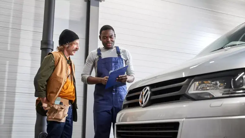Monteur en klant bij een Volkswagen Transporter